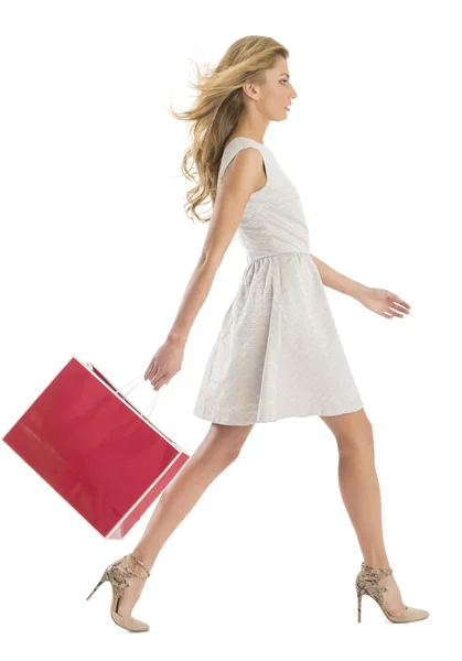 Вид сбоку на женщину, идущую с сумкой для покупок — стоковое фото