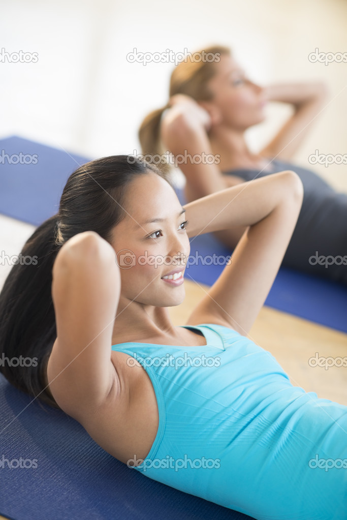 Woman Doing Sit-Ups At Health Club