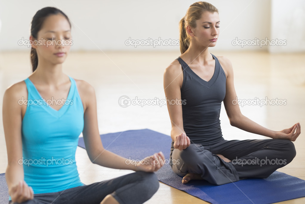Beautiful Women Practicing Yoga At Health Club