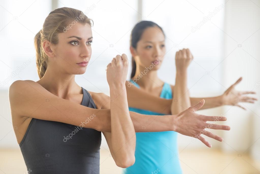 Women Looking Away While Doing Stretching Exercise