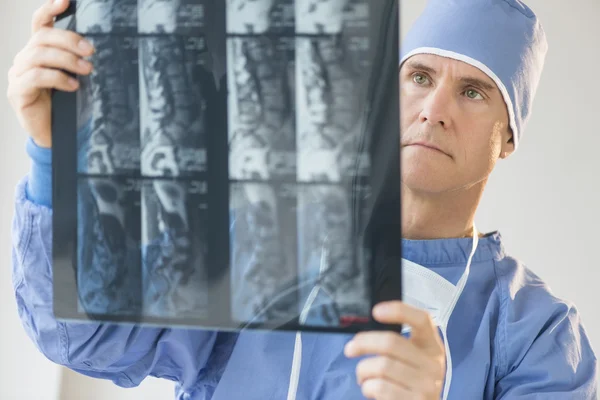 Manliga kirurgen undersöker röntgen rapport — Stockfoto