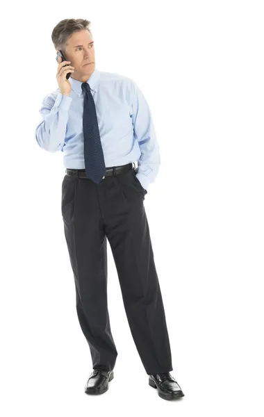 Geschäftsmann schaut weg, während er Smartphone beantwortet — Stockfoto