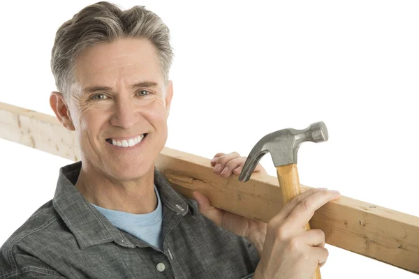 Carpintero macho feliz sosteniendo el martillo y el tablón —  Fotos de Stock