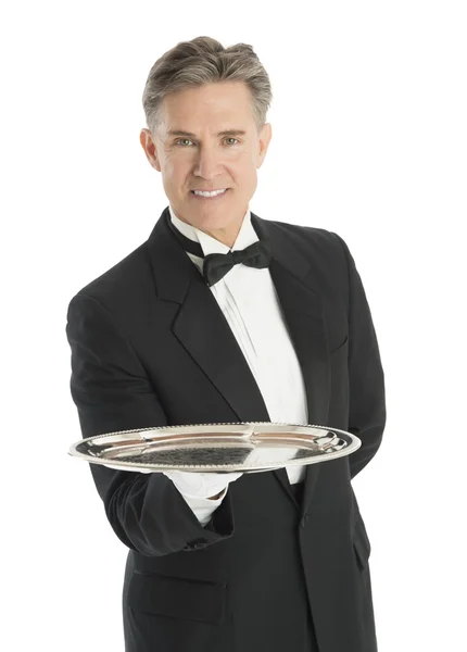 Портрет уверенного официанта в смокинге с сервировочным подносом — стоковое фото