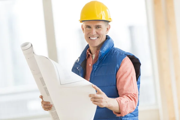 Happy Construction Worker Holding Blueprint At Site — Stock Photo, Image