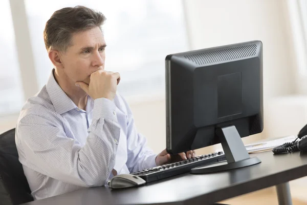 Empresario trabajando en PC de escritorio en la oficina —  Fotos de Stock
