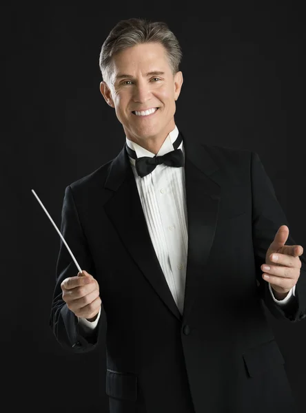 Portret van vertrouwen mannelijke muziek dirigent houden dirigeerstok — Stockfoto