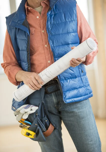 Midsection av byggnadsarbetare håller blueprint — Stockfoto