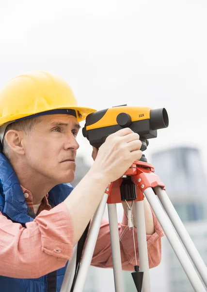 Obrero de la construcción midiendo distancias a través de teodolito —  Fotos de Stock