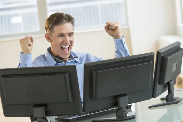 Úspěšný obchodník, křičí při použití více počítačů Stock Snímky