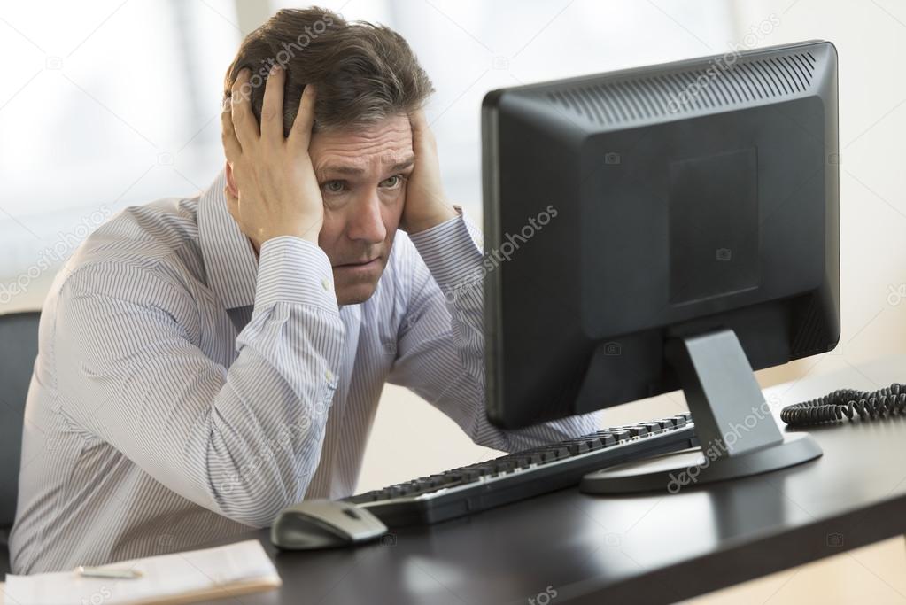 Exhausted Businessman Looking At Computer Monitor