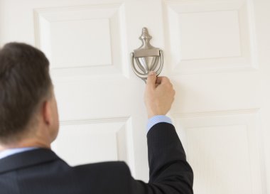 Businessman Knocking Door Knocker clipart