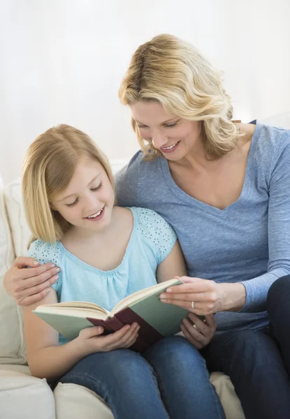 Madre e hija leyendo el libro juntas en casa —  Fotos de Stock