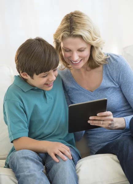 Mutter und Sohn nutzen gemeinsam digitales Tablet zu Hause — Stockfoto