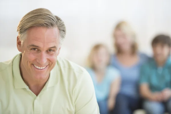 Šťastný muž s rodinou v pozadí doma — Stock fotografie