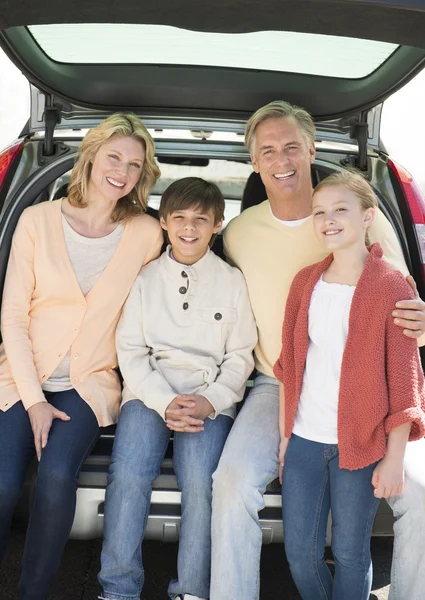 Famille heureuse de quatre assis dans le coffre de voiture — Photo