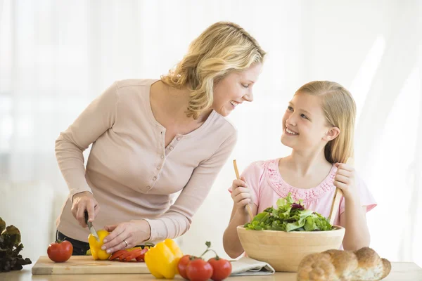 Anne ve kızı mutfakta yiyecek hazırlama