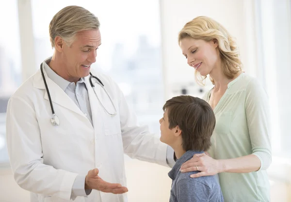 Läkaren förklarar gosse medan mamma titta på honom i kliniken — Stockfoto