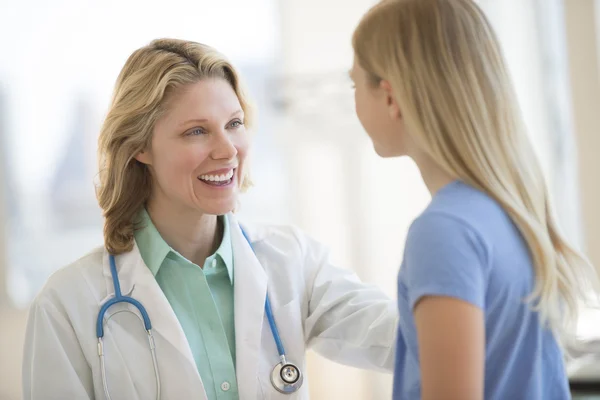 Female Doctor Looking At Girl In Clinic — Stock Photo, Image