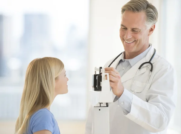 Doktor vyšetřující dívčí váhu v klinice — Stock fotografie