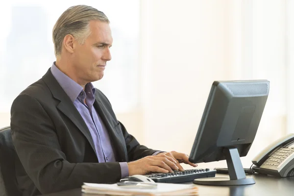 Affärsman med stationär dator i office — Stockfoto