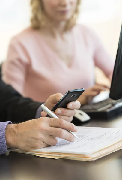 Podnikatel je ručně pomocí mobilního telefonu na stůl — Stock fotografie