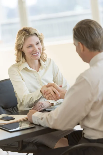 Businesswoman Shaking Hands With Colleague At Desk — Stock Photo, Image