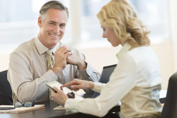 Uomo d'affari con collega femminile che utilizza la tavoletta digitale in ufficio — Foto Stock