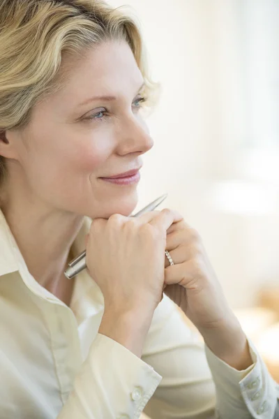 Businesswoman With Hand On Chin Looking Away In Office — Stock Photo, Image