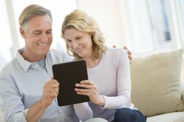 Couple utilisant une tablette numérique à la maison — Photo