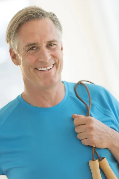 Homme avec corde à sauter souriant dans le club de santé — Photo