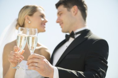 Gelin ve damat kadeh şampanya flüt gökyüzüne karşı