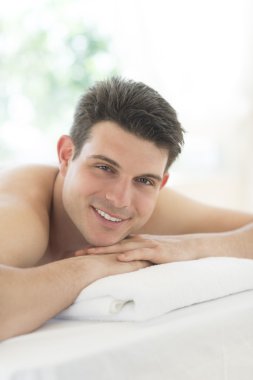 spa masaj masasında yatarken rahat adam
