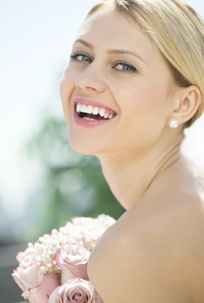 Fröhliche Braut mit Blumenstrauß — Stockfoto