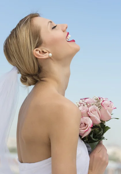 Braut mit dem Kopf nach hinten hält Blumenstrauß gegen den Himmel — Stockfoto