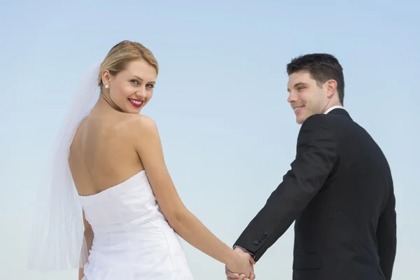 Bride Holding Groom's Hand Against Clear Blue Sky — Stock Photo, Image