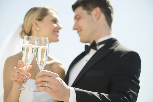 Sposa e sposo brindare Champagne Flauti contro il cielo — Foto Stock