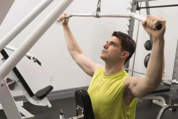 Uomo esercizio con puleggia in palestra — Foto Stock