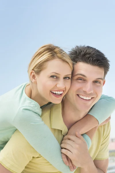 Playful Woman Embracing Man From Behind Against Clear Sky — Stock Photo, Image