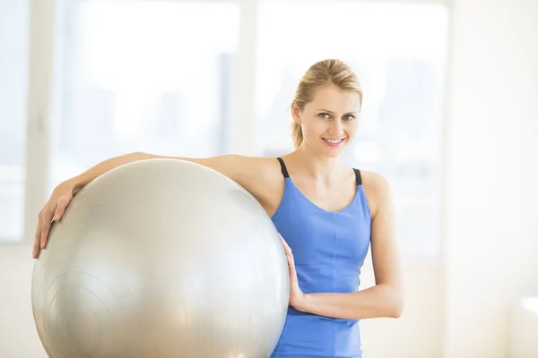 Hermosa mujer llevando pelota de fitness en el gimnasio — Foto de Stock