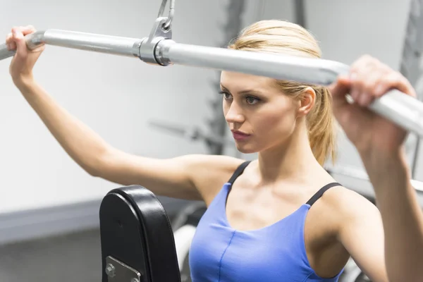 Donna che esercita con puleggia in palestra — Foto Stock