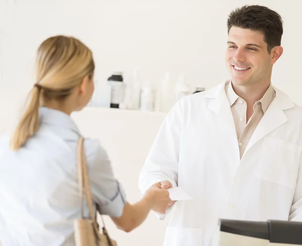 Pharmacist Receiving Prescription Paper From Customer At Store — Stock Photo, Image