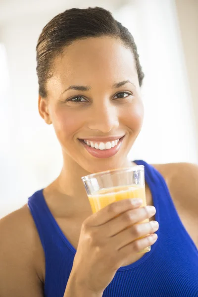 Mulher bonita segurando vidro de suco de laranja no ginásio — Fotografia de Stock