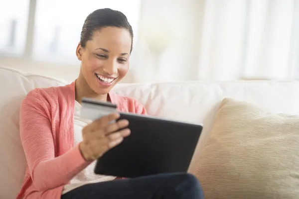Mujer con tarjeta de crédito y ordenador portátil de compras en línea en casa — Foto de Stock