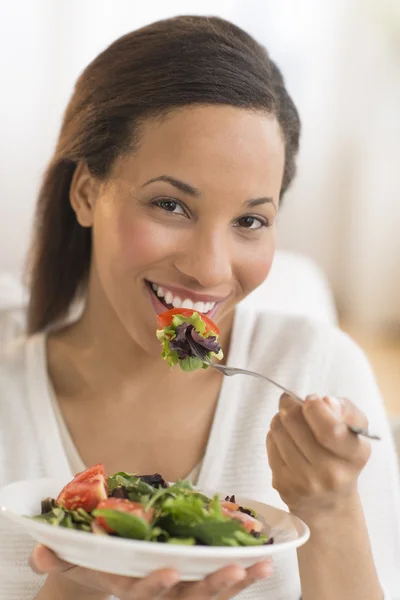 Gelukkige vrouw thuis eten van verse salade — Stockfoto