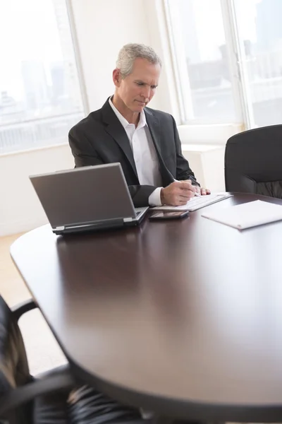 Zakenman schrijven op document aan balie — Stockfoto