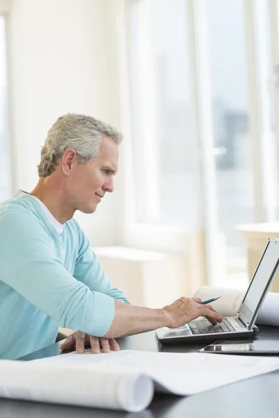 Arkitekt med laptop på skrivbordet — Stockfoto