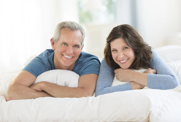 Portrét šťastnému páru leží vedle sebe v posteli — Stock fotografie