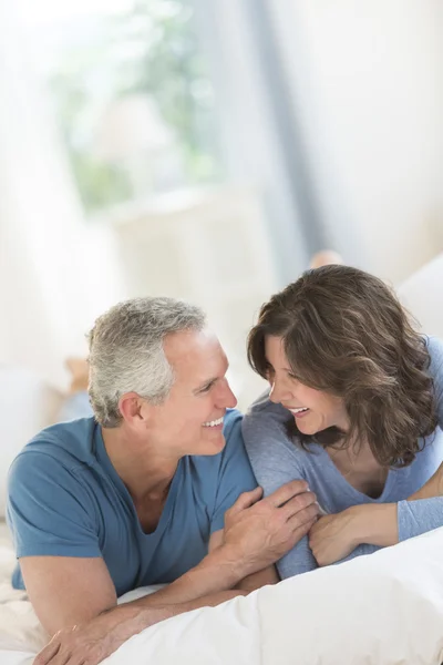 Paret tittar på varandra medan du kopplar av i sängen — Stockfoto