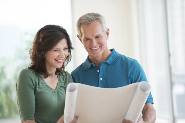 Paar op zoek naar blauwdruk in nieuw huis — Stockfoto